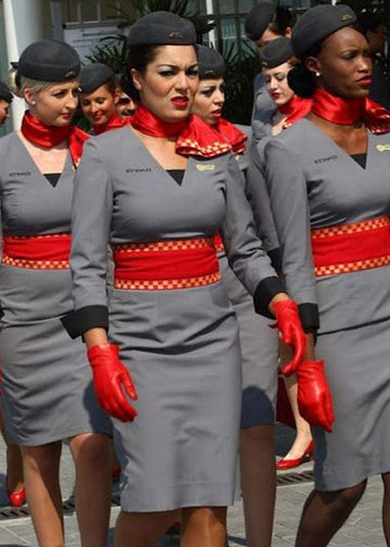 Group of women in uniform with red accents walking together.