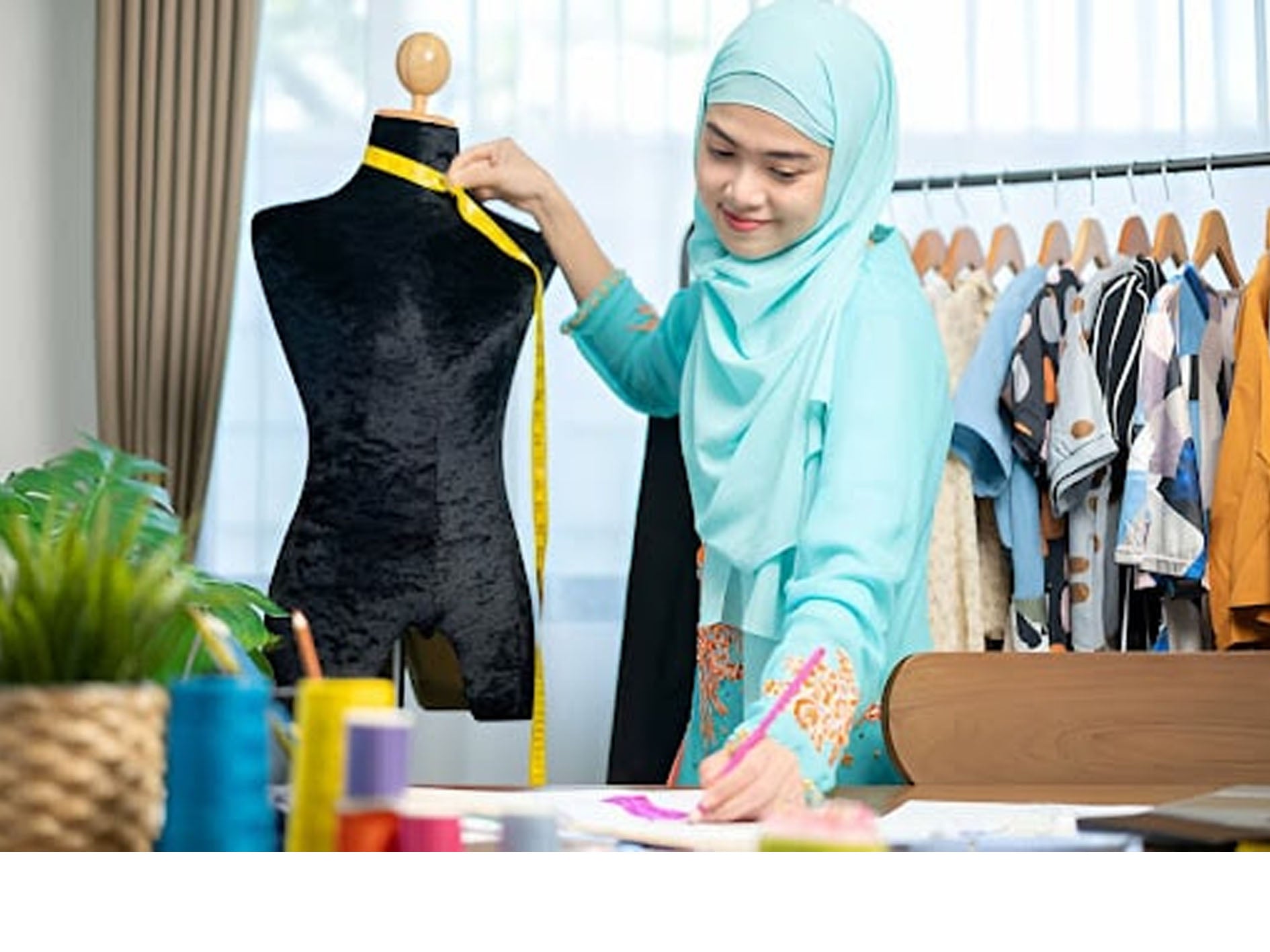 Lady abaya tailoring taking measurement on a shop background