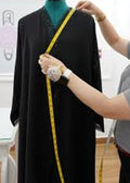 Lady measuring abaya for alteration