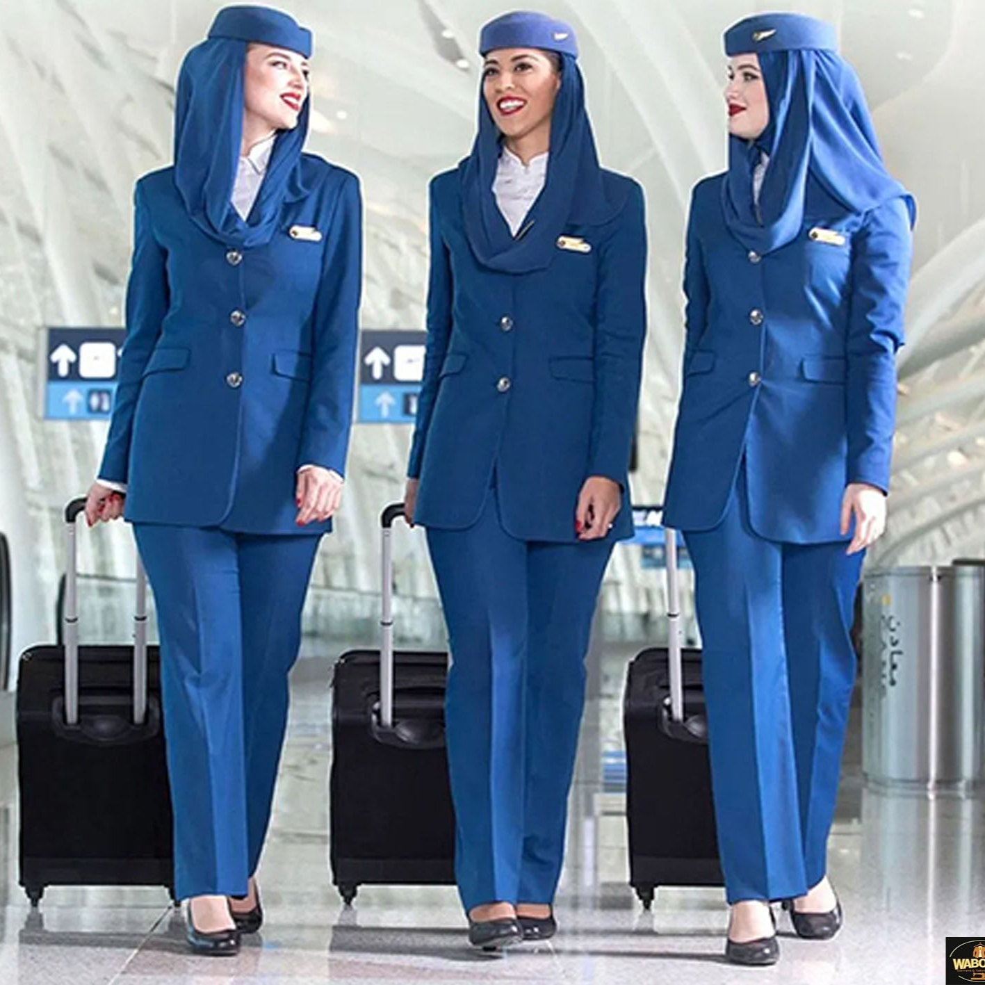 Three airline staff in blue uniforms standing in an airport terminal.