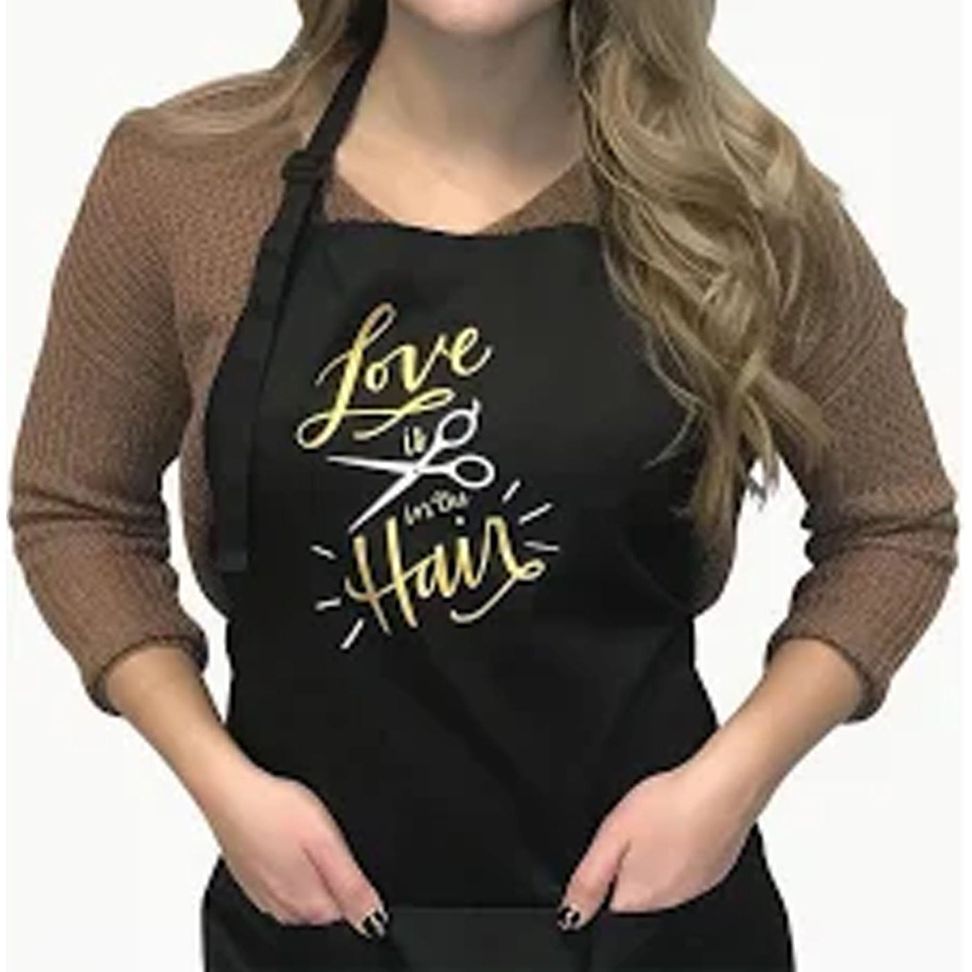 Person wearing a black apron with 'Love is in the Hair' text on a white background