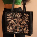Ladyholding a black floral embroidered hand bag 
