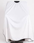A white barber cape draped over a chair on a stand, shown against a plain light gray background.