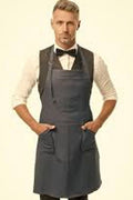 Man wearing a gray apron over a white shirt with a bow tie on a beige background