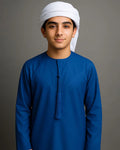 Person wearing a blue traditional outfit with a white headscarf on a gray background