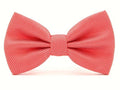 A coral red pre-tied bow tie with a fine white geometric grid pattern, shown against a plain white background.