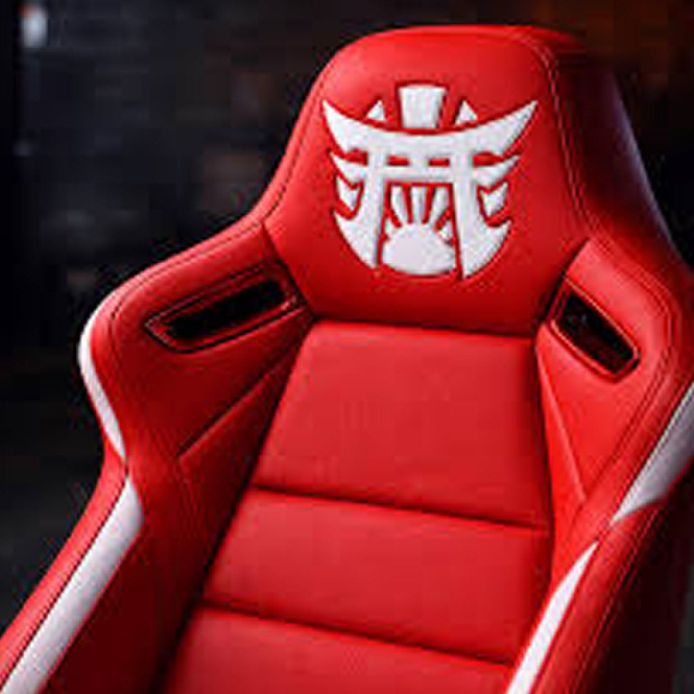Red car seat with a white logo on a dark background
