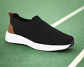 Black slip-on shoe with white sole on a white background