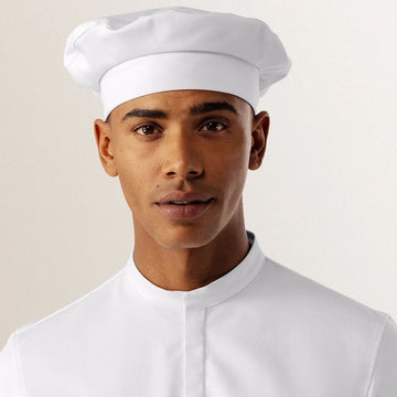 Person wearing a white uniform and hat on a plain background