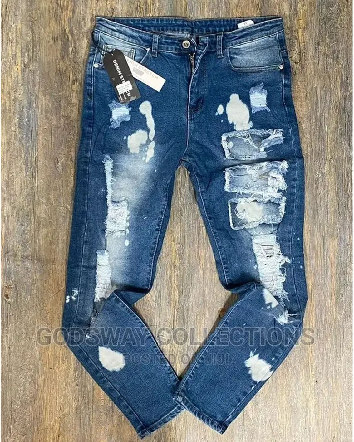 Distressed blue jeans on a wooden surface