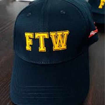 Navy blue cap with 'FTW' in yellow on a wooden surface