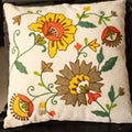 Decorative pillow with floral embroidery on a plain background
