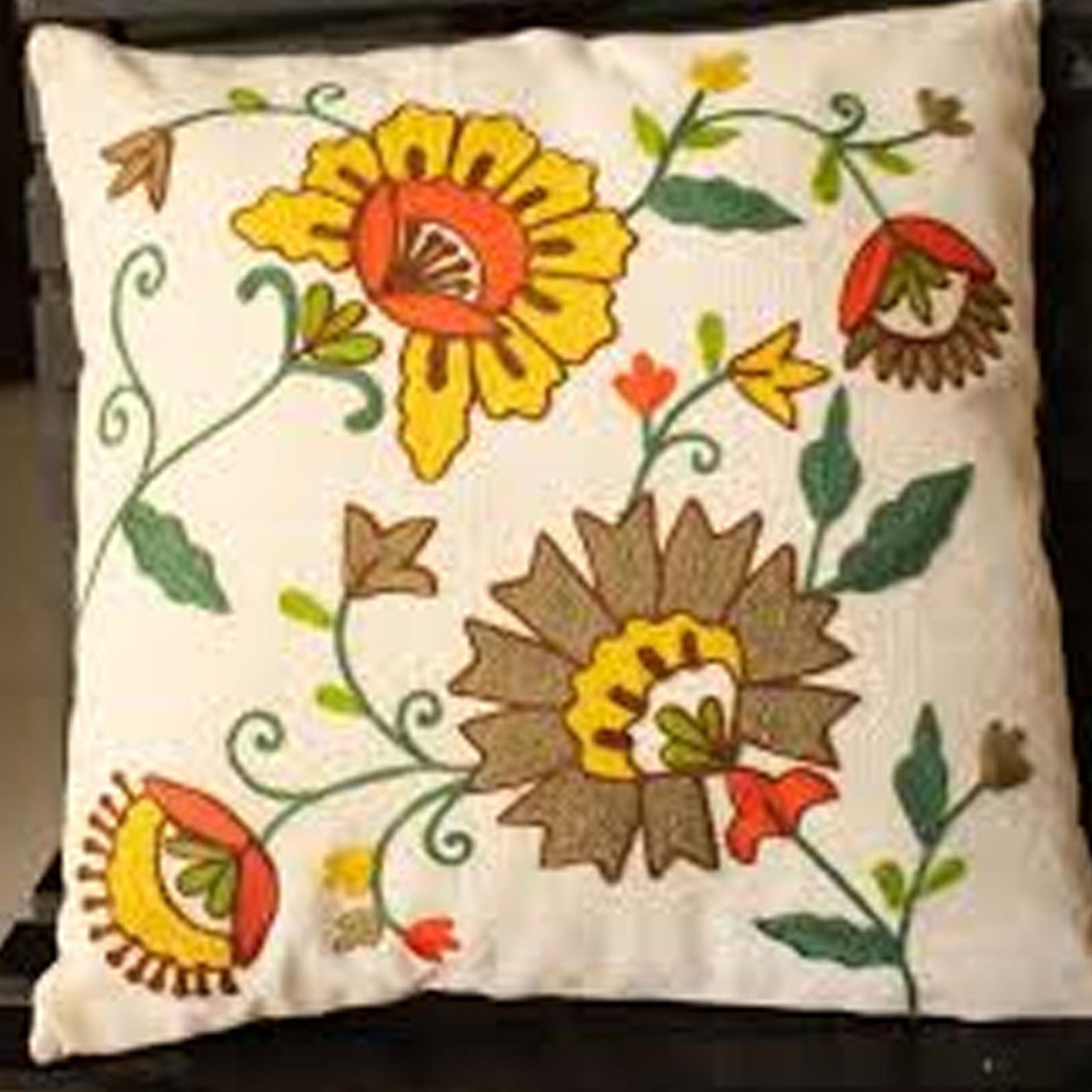 Decorative pillow with floral embroidery on a plain background