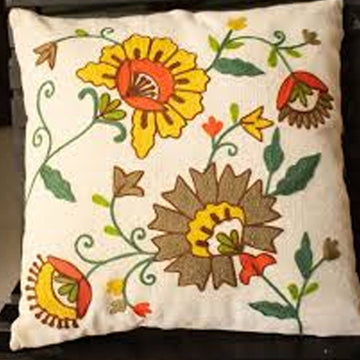 Decorative pillow with floral embroidery on a plain background