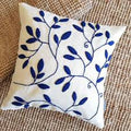 Decorative pillow with blue leaf pattern on a textured surface