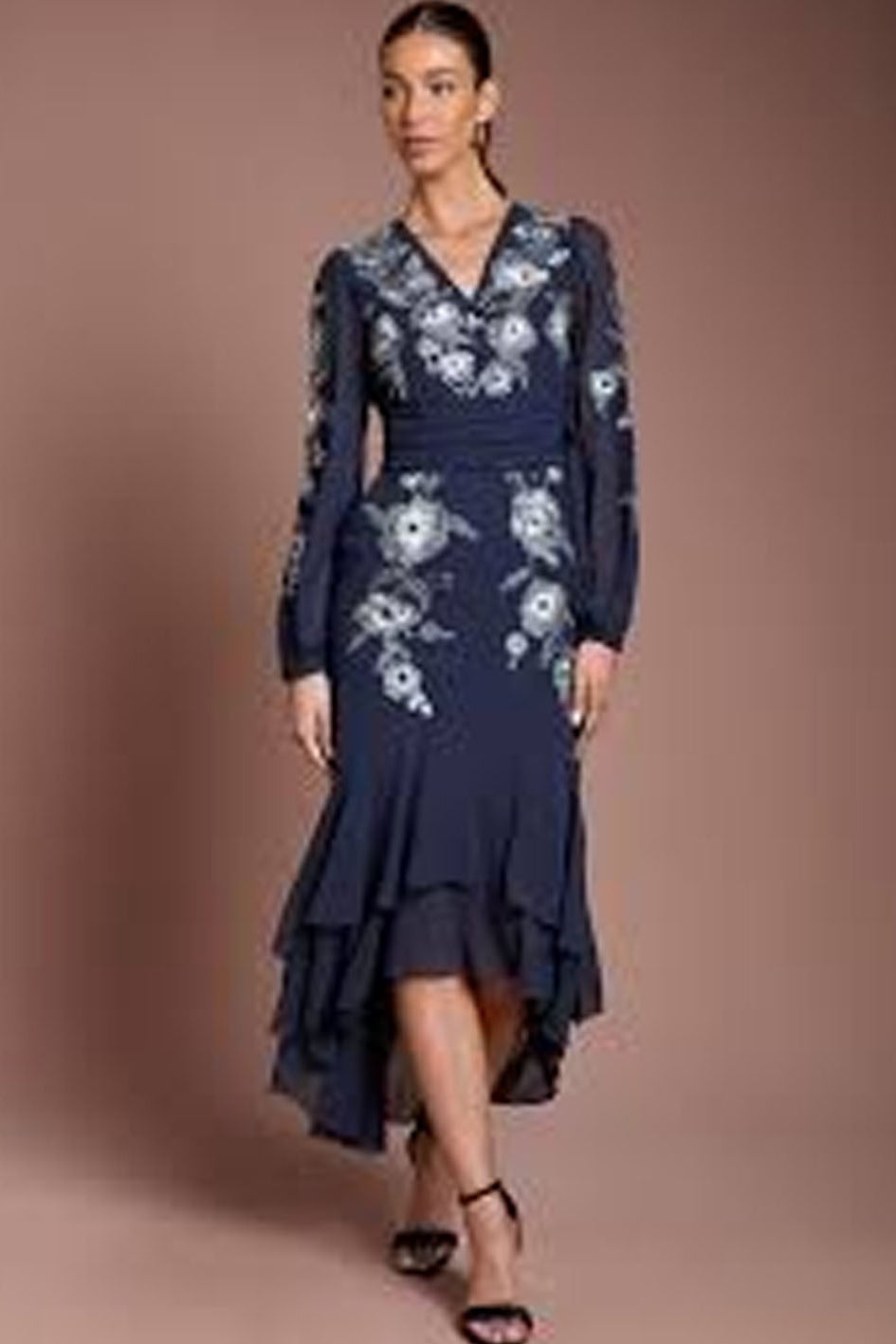 Lady wearing a navy blue dress with floral embroidered design
