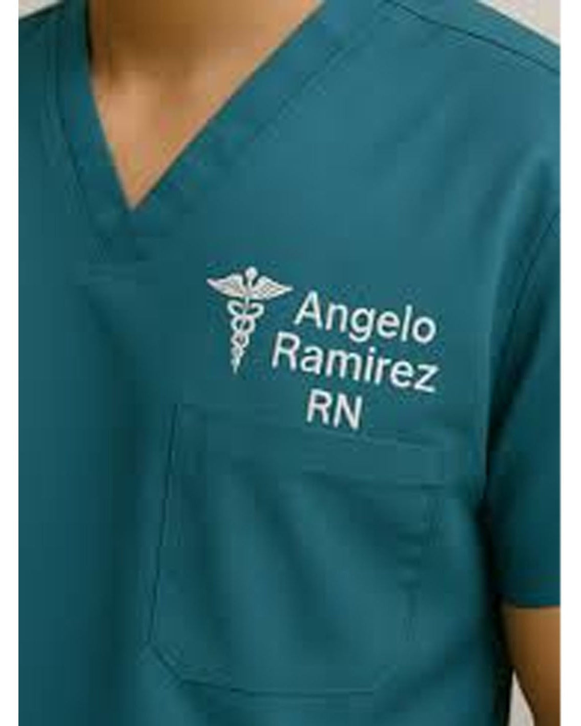 Teal scrub top with embroidered name and title on a white background