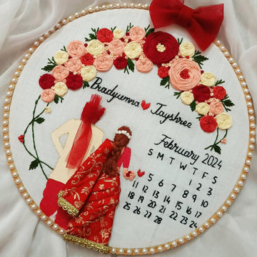 Decorative calendar with floral design and couple in red outfits on a white background