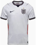 A white Nike England soccer jersey with a navy and white striped V-neck collar, black Nike swoosh on the right chest, and the England crest on the left chest.