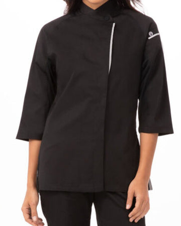 A woman wearing a black three-quarter sleeve chef jacket with a silver zipper detail down the front and a small white logo on the upper sleeve, set against a plain white background.