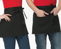 Two people wearing black aprons over red shirts on a white background