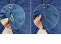 Close-up of a blue denim fabric with a zipper, showing a detailed view.