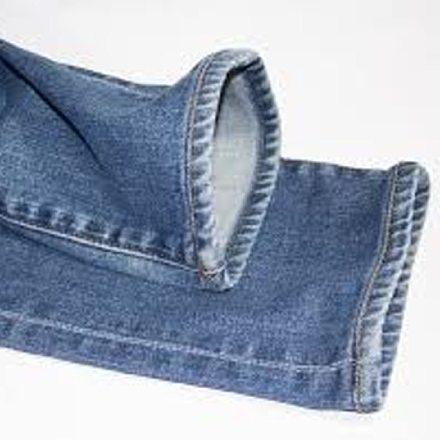 Close-up of blue jeans with a white background