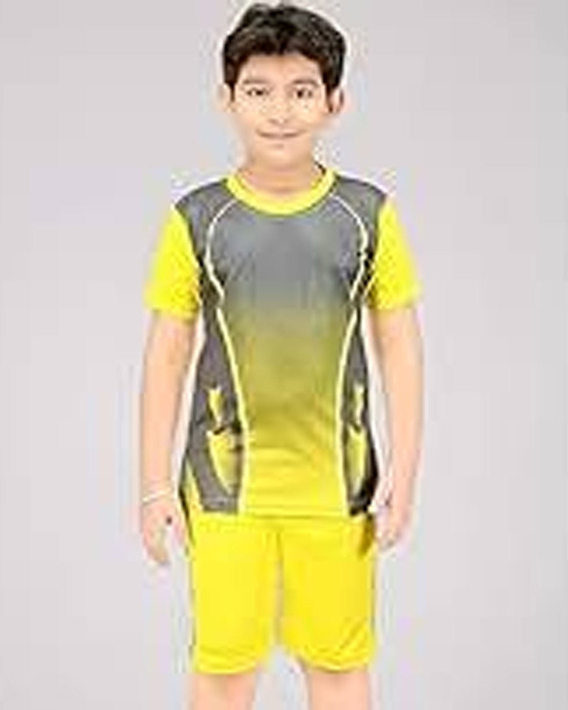 Child wearing a yellow and gray sports outfit on a plain background