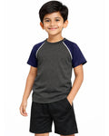 Child wearing a gray and navy shirt with black shorts on a white background