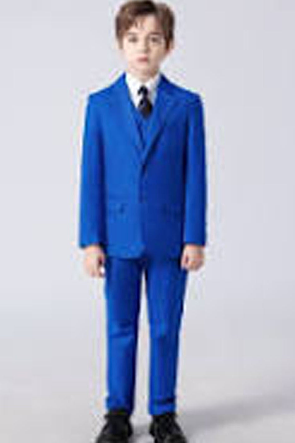Child wearing a blue suit against a plain background
