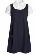 Navy pinafore dress over a white shirt on a white background
