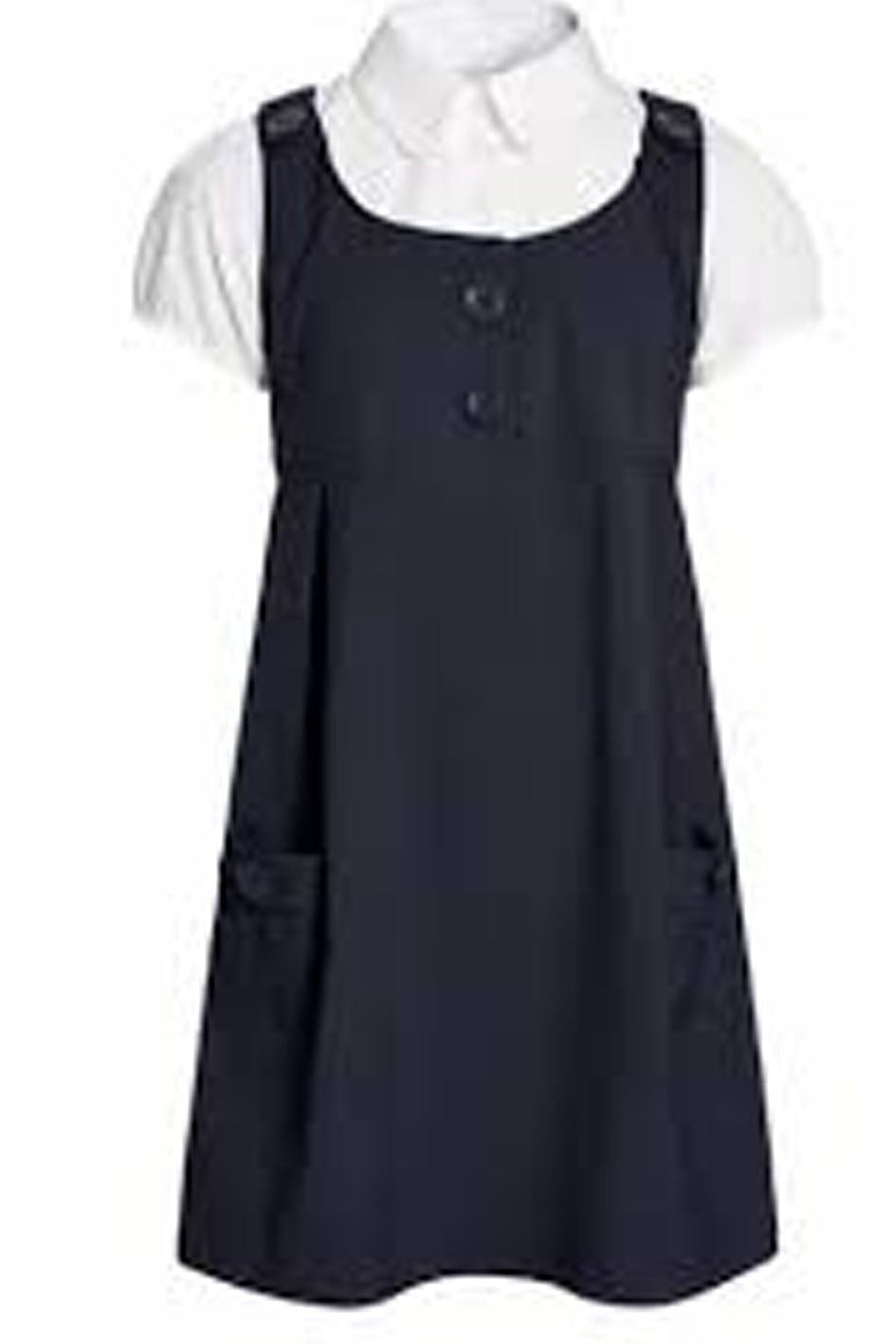 Navy pinafore dress over a white shirt on a white background