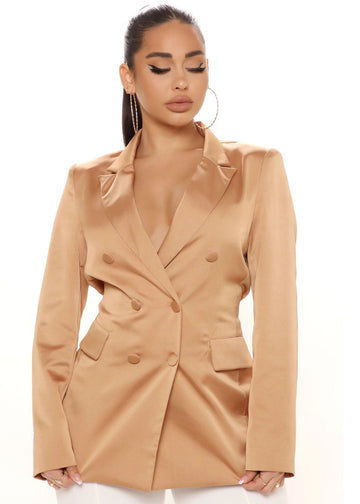 Woman wearing a beige blazer on a white background