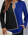 Black and blue long-sleeve top with decorative trim worn by a person.