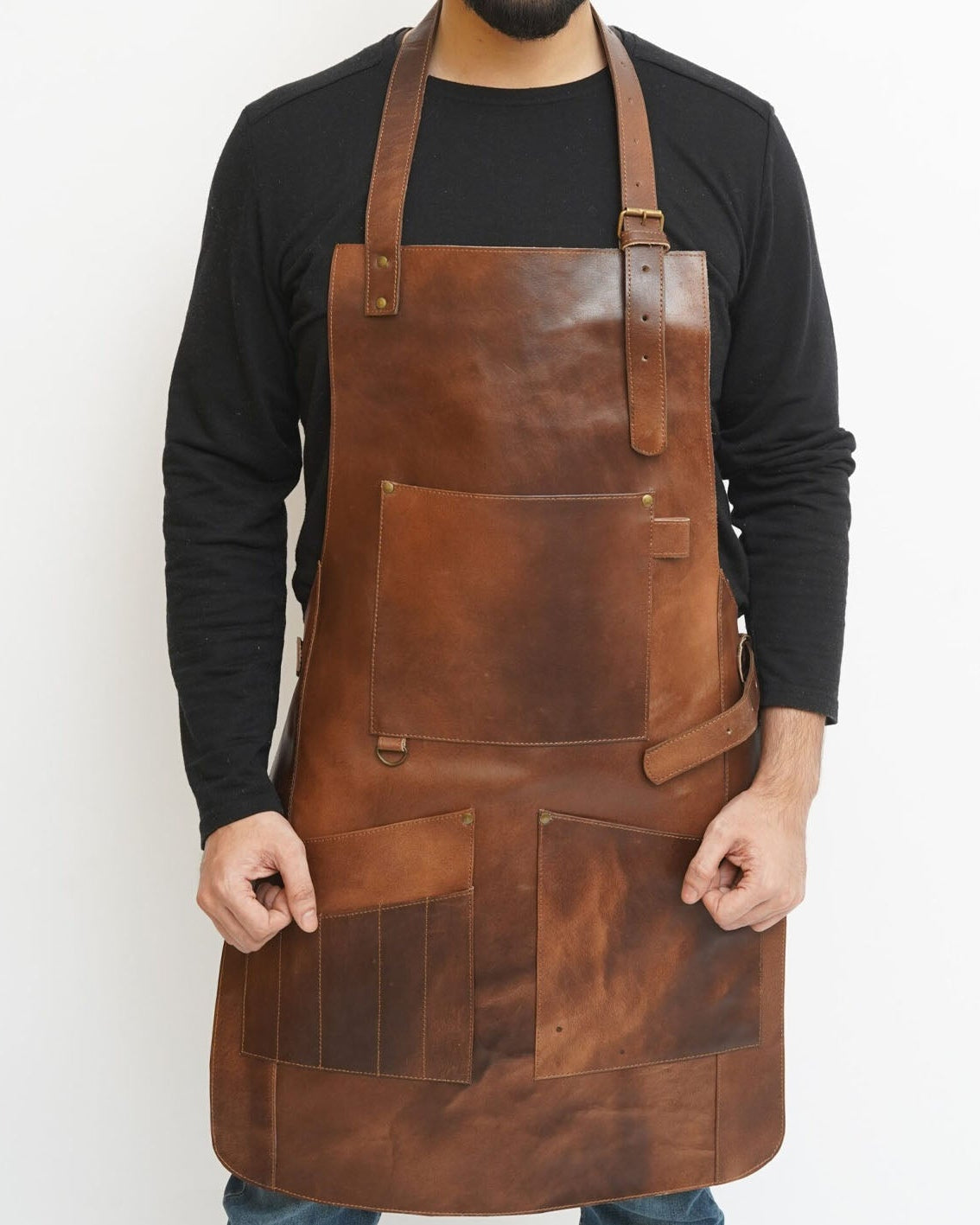 Brown leather apron worn by a person on a white background