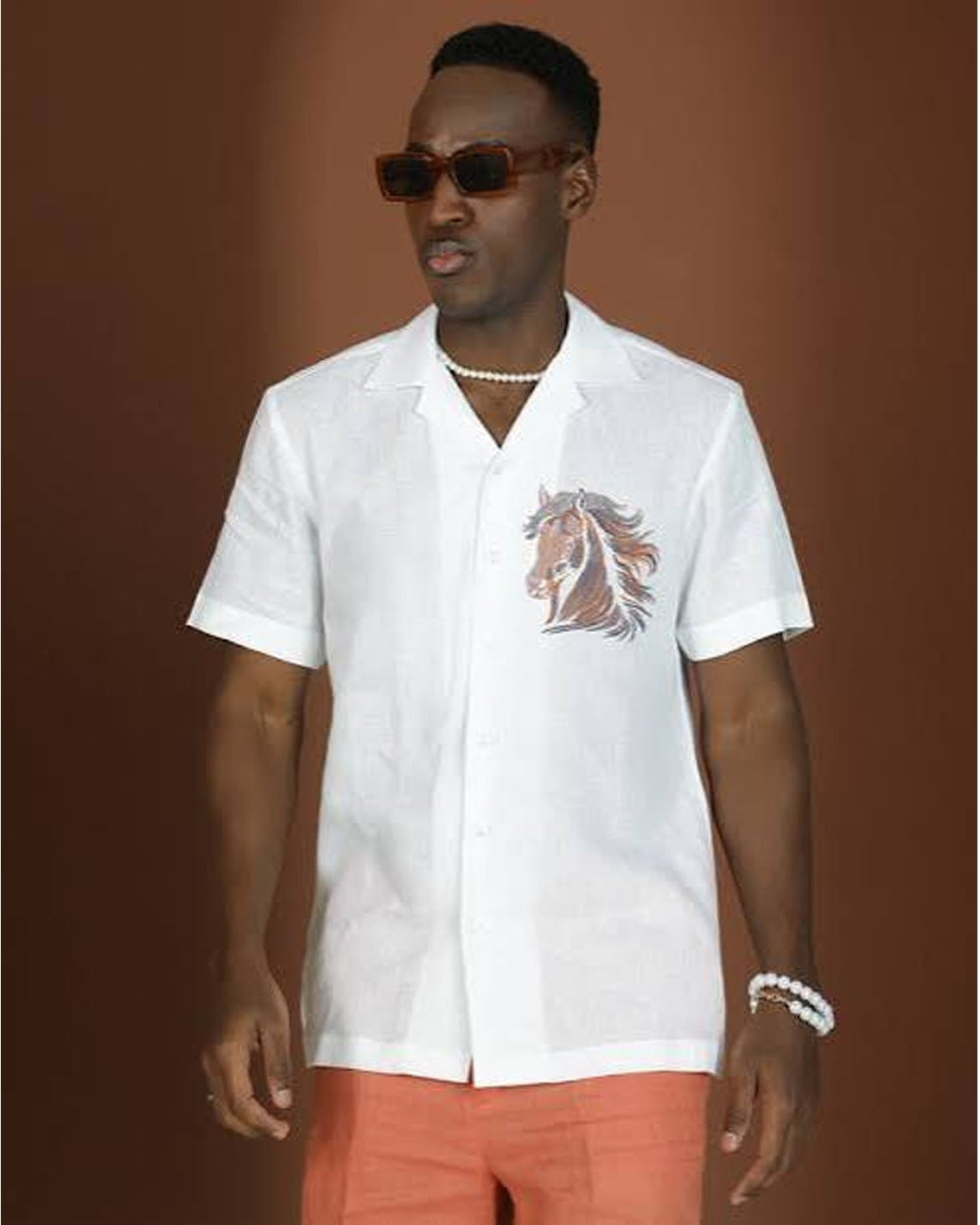 A man wearing an embroidered linen shirt