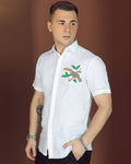 A man wearing a white linen with embroidered flower