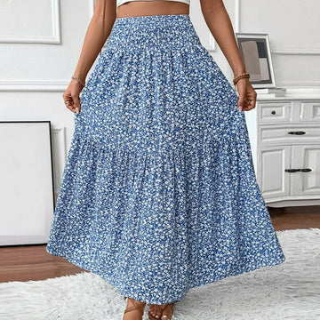 Person wearing a blue floral skirt in a room with white walls and furniture.