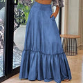 Woman wearing a long blue denim skirt in an indoor setting.