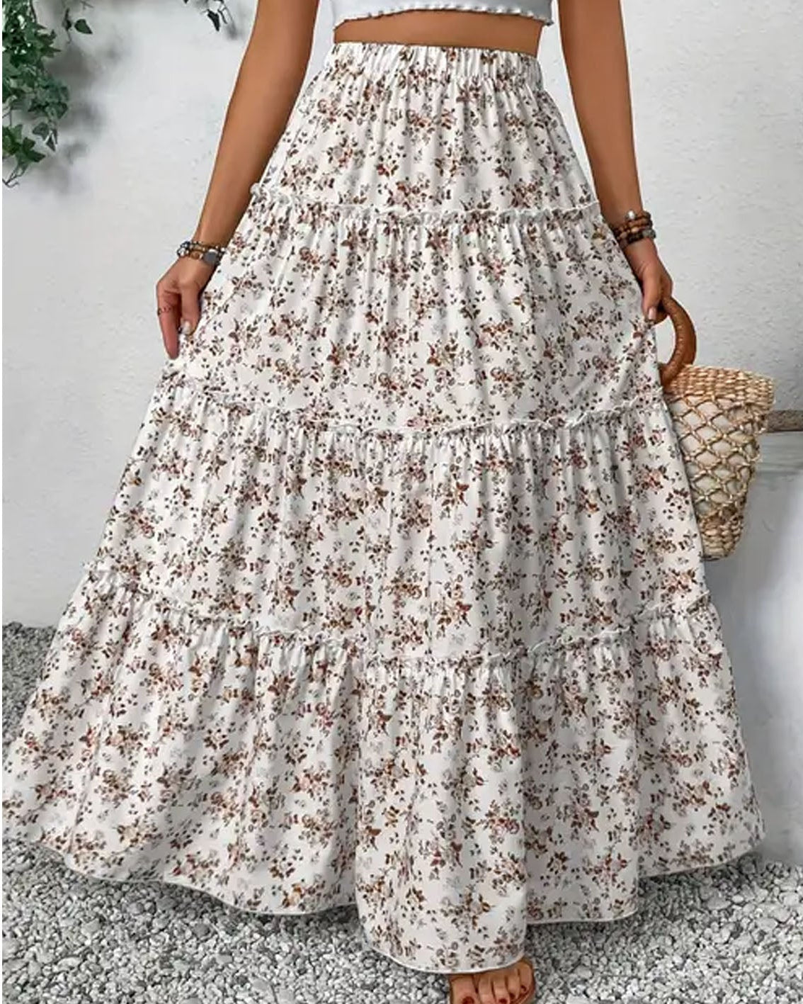 Long floral skirt worn by a person on a light gray background