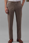 Brown dress pants worn by a person on a gray background