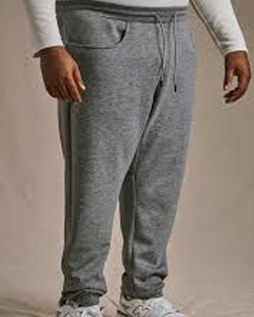 Person wearing gray sweatpants on a beige background