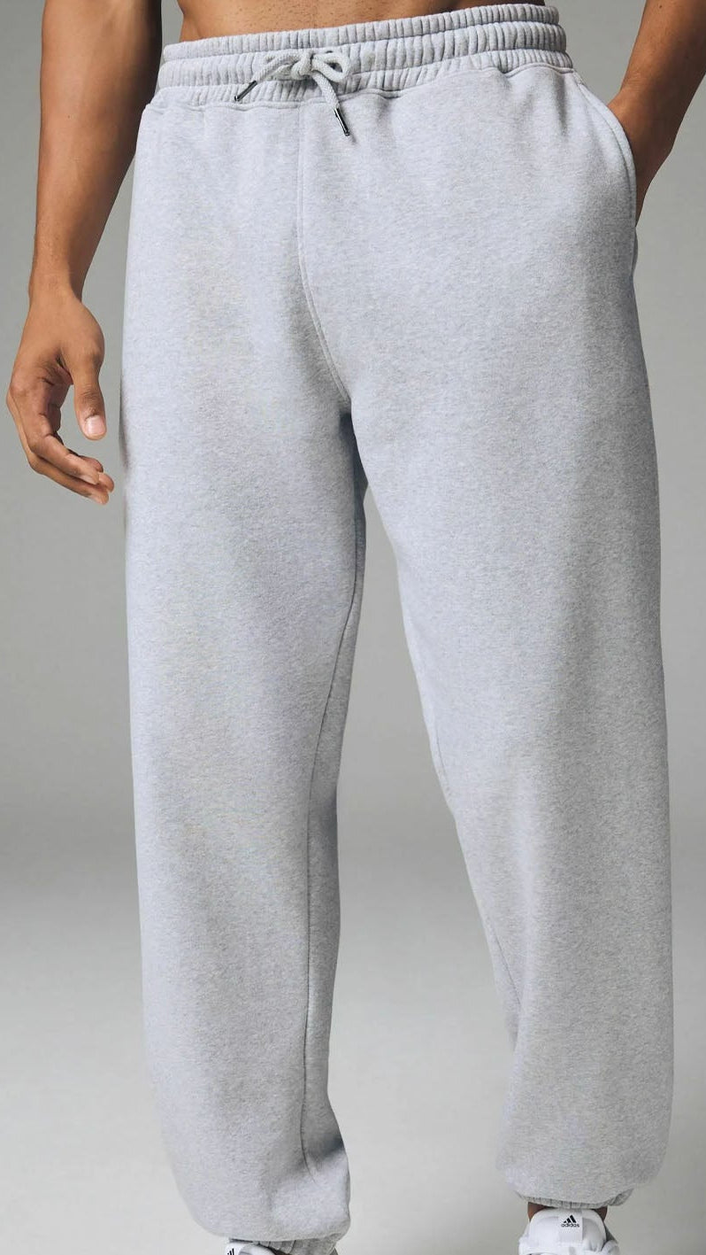 Gray sweatpants worn by a person on a gray background