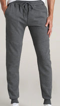 Gray sweatpants worn by a person on a plain background
