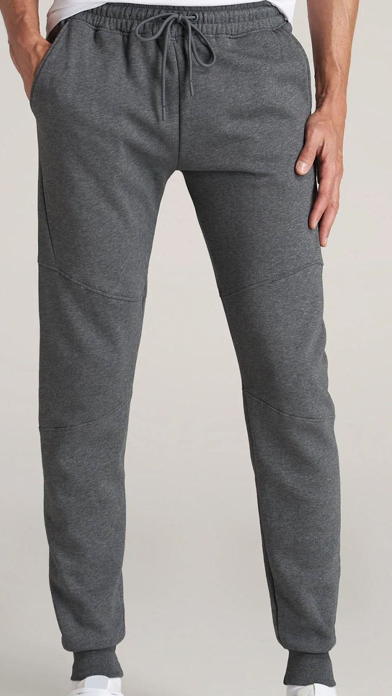 Gray sweatpants worn by a person on a plain background