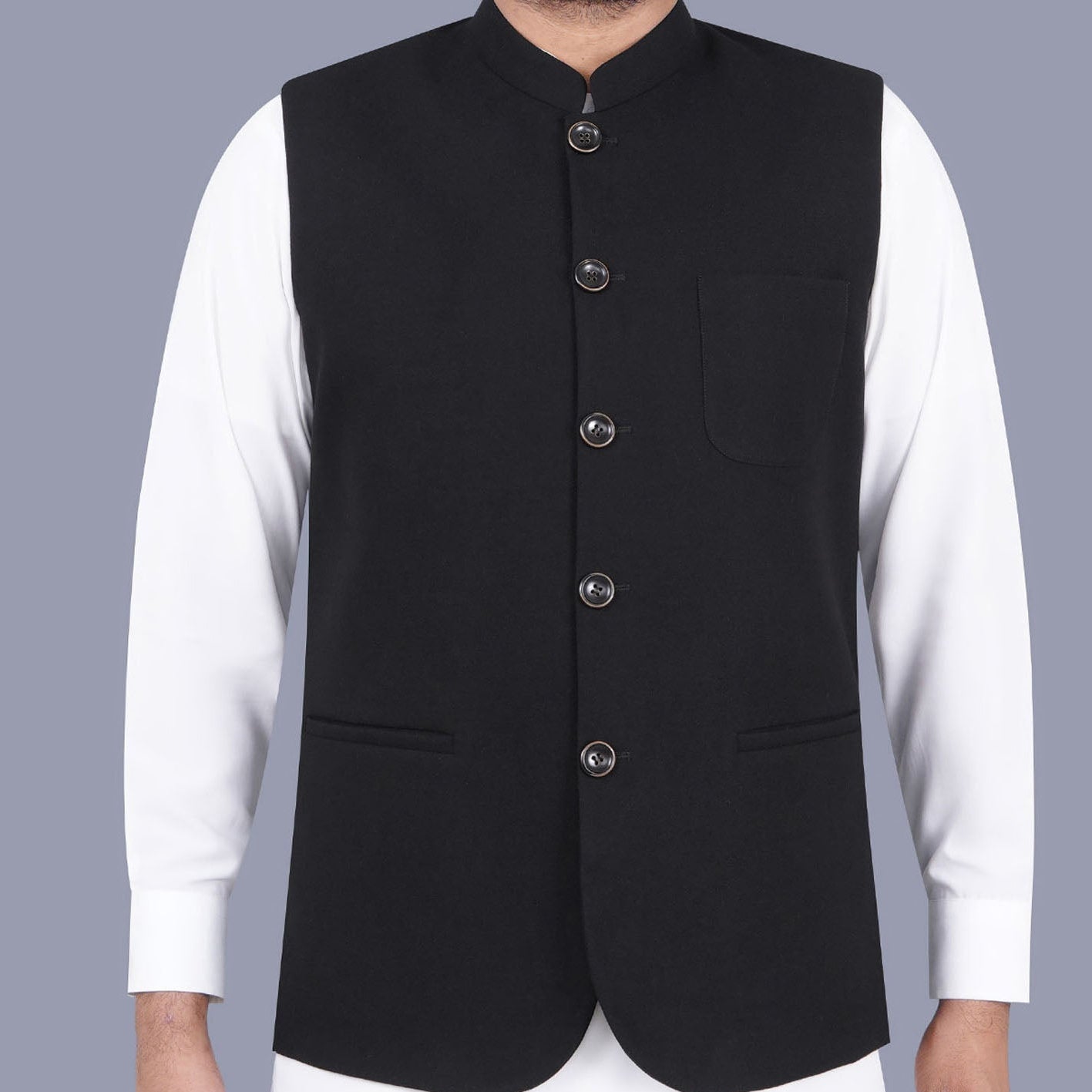 Black vest over a white shirt on a gray background