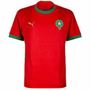 Red sports jersey with green accents and Puma logo on a white background
