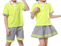 Two children modeling matching high-visibility neon yellow school uniforms, including polo shirts and striped skirts or shorts, against a plain white background.