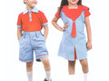 Two children modeling matching school uniform sets against a plain white background. The boy wears a short-sleeve polo shirt with a light blue collar and cuffs, paired with light blue shorts.