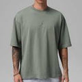 Person wearing a green t-shirt against a gray background